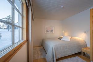 un dormitorio con una cama y una ventana en Holiday Apartment Teerenpesue A5, en Saariselkä
