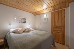 Un dormitorio con una cama y un techo de madera. en Holiday Apartment Teerenpesue A5, en Saariselkä