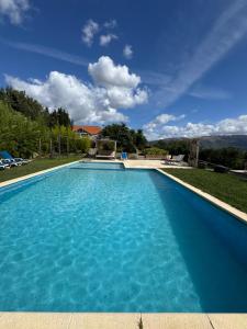 a large swimming pool with blue water at Quinta São José - Museu do Triciclo in Mesão Frio