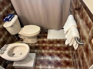 a bathroom with a toilet and a sink with towels at Miami Spacious Executive Suite in Miami