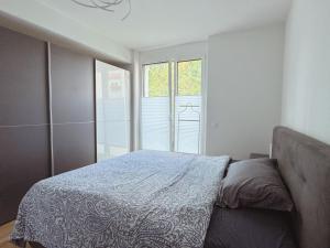 a bedroom with a bed and a large window at Modern 3-Room Apartment in Stuttgart City Area in Stuttgart
