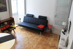 ein Wohnzimmer mit einem blauen Sofa und einem Tisch in der Unterkunft Casa da Catedral in Porto