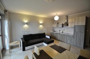 un salon avec un canapé et une cuisine dans l'établissement Apartament Spokojny, à Kościelisko