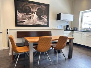 a kitchen with a dining room table and chairs at Iderhoff Lounge 01 in Norderney