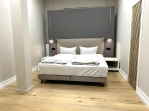 a bedroom with a bed with white sheets and pillows at Iderhoff Lounge 01 in Norderney +6 photos