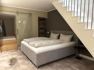a bedroom with a bed and a staircase at Iderhoff Lounge 01 in Norderney
