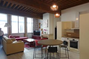 a kitchen and living room with a table and chairs at Côté Palais in Lyon