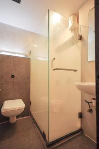 a bathroom with a shower and a toilet and a sink at Hotel Akasa International Near T-2 International Airport Mumbai in Mumbai +39 photos