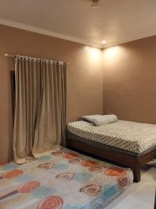 1 dormitorio con 2 camas individuales y cortina en Station house ijen, en Banyuwangi