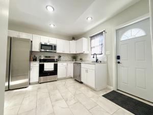 a kitchen with white cabinets and a stainless steel refrigerator at Town & Country Andover NJ Area-1st Floor 2 Bedroom in Newton