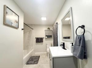 a bathroom with a sink and a toilet and a mirror at Town & Country Andover NJ Area-1st Floor 2 Bedroom in Newton