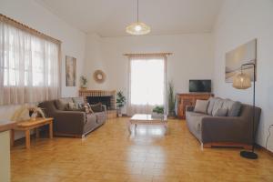 a living room with two couches and a television at Sea house of Candia in Kandia