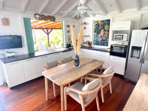 a kitchen with a wooden table and some chairs at villa La Poudrière in Deshaies