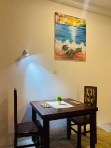 a dining room table with a painting on the wall at Revival Beach Resort in Hikkaduwa +35 photos