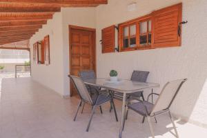 a table and chairs in a patio with a door at Sea house of Candia in Kandia
