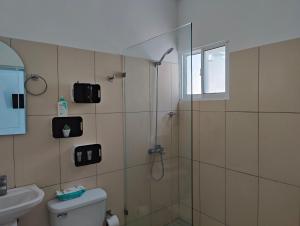 a bathroom with a shower and a toilet and a sink at Azure Breeze Hotel in Bayahibe