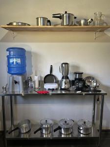 a shelf with pots and pans on top of a stove at White cabin - Casa de Campo em Gonçalves - MG in Gonçalves
