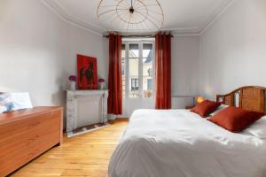 a bedroom with a large bed and a large window at Appartement André Thérèse, calme Belle Epoque in Vichy