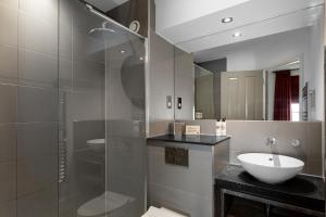a bathroom with a glass shower and a sink at Rose And Crown Hotel in London +28 photos