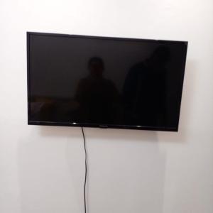 Un televisor de pantalla plana colgado en una pared en Praia Grande Aviação Apto Disney, en Praia Grande