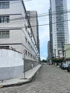 una persona caminando por una calle en una ciudad en Praia Grande Aviação Apto Disney, en Praia Grande 21 fotos más
