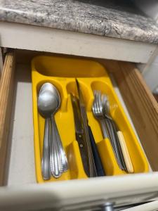 Una bandeja amarilla con utensilios de plata sobre una encimera en Praia Grande Aviação Apto Disney, en Praia Grande