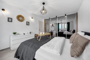 a bedroom with a large bed with a table on it at Gocław Apartment - 48m2, Balcony - by Rentujemy in Warsaw
