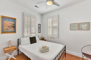 チャールストンにあるRetreat on Spring, Unit Bのベッドルーム1室(白い壁と窓のあるベッド1台付)