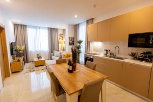 a kitchen and living room with a wooden table and a dining room at Stylish Apartment with Modern Amenities in Nova Roman Ridge in Accra