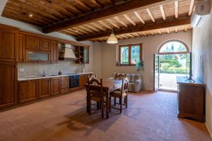 a kitchen with wooden cabinets and a table with chairs at Il Colle Verde in Buonconvento
