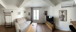 ein Wohnzimmer mit Sofa und Fernseher in der Unterkunft Charming and very central 2 rooms apartment in Bandol