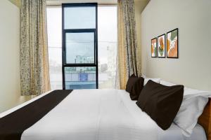 a bedroom with a large bed with a large window at Hotel O SRL Comforts in Kumbalgod
