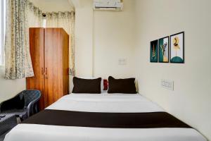 a bedroom with a bed and a chair at Hotel O SRL Comforts in Kumbalgod