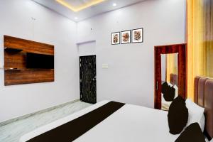 una camera da letto con un letto e una TV a parete di HOTEL O JANKI Kalyanpur Railway Station a Kānpur