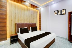 una camera da letto con un grande letto bianco e una parete in legno di HOTEL O JANKI Kalyanpur Railway Station a Kānpur