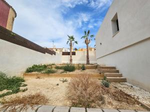 a building with stairs and palm trees in front of it at Fee4me Exclusive Villa with Pool and Parking in Mutxamel