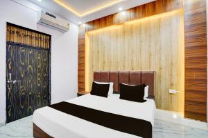una camera da letto con un letto e una parete di legno di HOTEL O JANKI Kalyanpur Railway Station a Kānpur