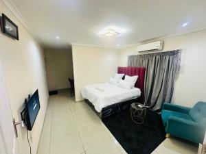 a hotel room with a bed and a blue chair at Joy House in Cape Town
