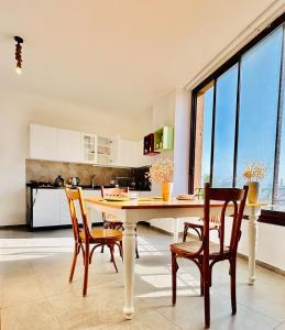 a kitchen with a table and chairs in a room at La Luna Luz 1BR Apt w Balcony by the Bahsa Sea in Batroûn