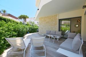 a patio with white chairs and a table at Luxury Apartment Zen - by Welcomely in Platja de l'Arenal +10 photos