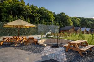a patio with two picnic tables and an umbrella at The Cabin Retreat Piešťany 