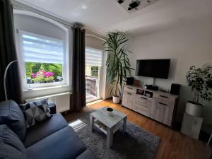 a living room with a blue couch and a tv at Ferienwohnung im Zschopauer Herzen in Zschopau