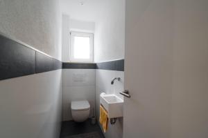 a bathroom with a toilet and a sink and a window at Anita's Fewo in Ulm +17 photos