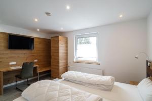 a bedroom with a bed and a desk and a television at Anita's Fewo in Ulm