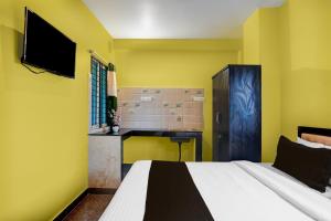 1 dormitorio con paredes amarillas, 1 cama y TV en Hotel O Royal Avisi Residency, en Bhubaneshwar 27 fotos más