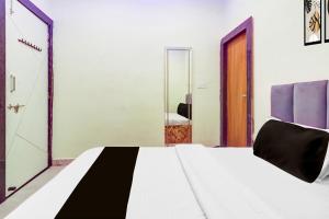 a bedroom with a white bed and a mirror at Hotel O Silver Cloud in Gwalior