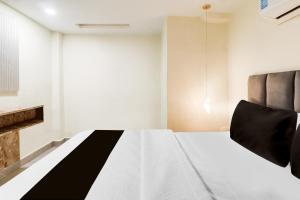a bedroom with a bed with black and white sheets at Hotel O Silver Cloud in Gwalior