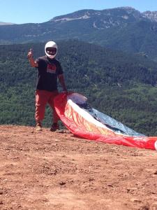 a man standing on top of a mountain holding a kite at Albergue Pájaro Loco in Castejón de Sos