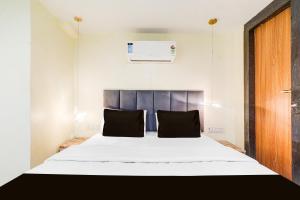a bedroom with a large white bed with black pillows at Hotel O Silver Cloud in Gwalior +21 photos