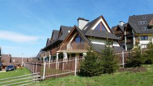 une maison avec une clôture devant dans l'établissement Apartament Spokojny, à Kościelisko